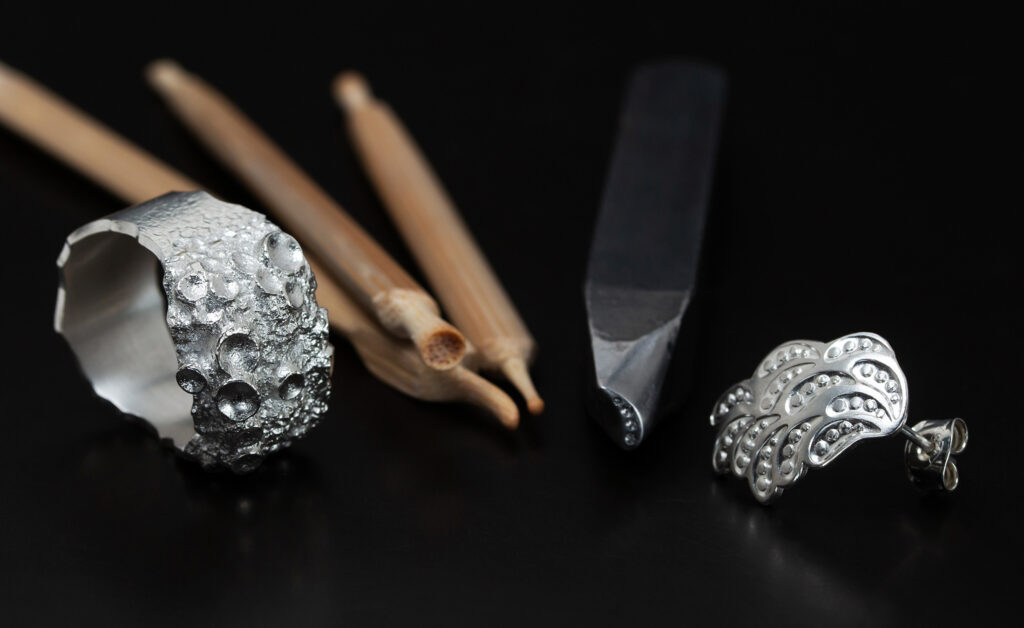 Sandgjuten silverring med verktyg och örhänge med stämplad dekor och tämpel. Petronella Eriksson. Smycken som bär på spår och lämnar avtryck